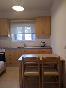 - une cuisine avec des placards en bois, une table et des chaises dans l'établissement Alex apartment, à Saranda