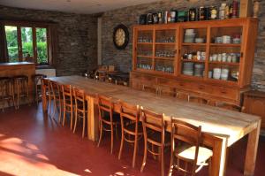 a dining room with a large wooden table and chairs at La Balade in Laforêt