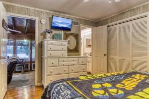 una camera da letto con cassettiera e TV a parete di Live Luv Lake a Dandridge