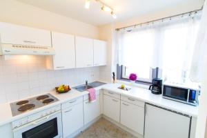 a white kitchen with a sink and a microwave at Apartment Hernalser Hauptstraße in Vienna