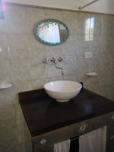 a bathroom with a sink and a mirror on a counter at Kailash Posada in San Marcos Sierras +21 photos