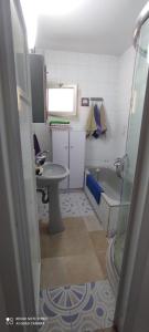a small bathroom with a sink and a tub at Apartments Haagna in Ashdod