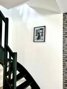 a stairway with a picture on a white wall at La Française - 85m2 in Vierzon