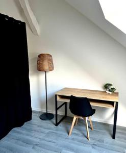 a desk with a chair and a lamp in a room at La Française - 85m2 in Vierzon