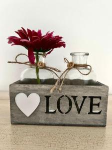 une boîte en bois avec un vase avec un cœur et une fleur dans l'établissement La Française - 85m2, à Vierzon