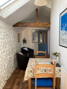 uma sala de jantar com uma mesa e uma cadeira em The Old Barn Annexe em West Runton