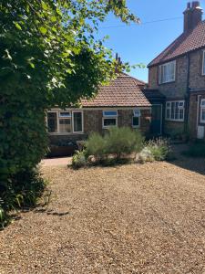 ein Haus mit Kieseinfahrt davor in der Unterkunft The Old Barn Annexe in West Runton