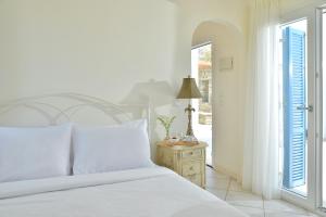 sypialnia z łóżkiem i otwartymi drzwiami w obiekcie Andros Homes Sea Side Apartment & Studio w mieście Gavrion