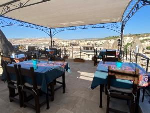 un patio con mesas y sillas y vistas. en Turquaz Cave Hotel en Göreme