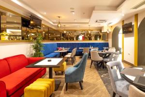 een restaurant met een rode bank en tafels en stoelen bij Hotel Cataleya in Šabac