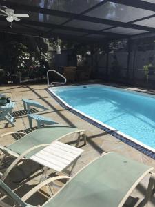 a large swimming pool with chairs and a table at 1620 - 5-Room Apt. with Pool & Gardens , Near Downtown in St. Petersburg