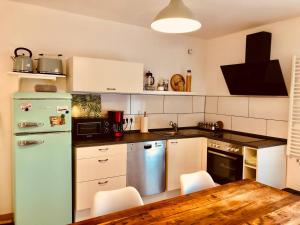 Il comprend une cuisine équipée d'un réfrigérateur vert et d'une table en bois. dans l'établissement Ferienwohnung Am Pieperknapp in Olsberg, à Olsberg
