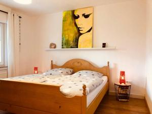 1 dormitorio con 1 cama con una pintura en la pared en Ferienwohnung Am Pieperknapp in Olsberg, en Olsberg