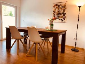 a dining room table with chairs and a vase of flowers at Ferienwohnung Am Pieperknapp in Olsberg in Olsberg