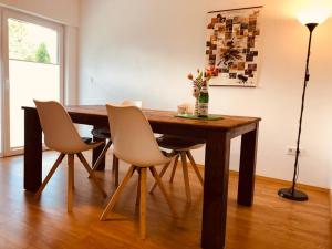 una mesa de comedor con sillas y un jarrón de flores en Ferienwohnung Am Pieperknapp in Olsberg, en Olsberg