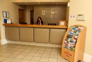 a woman sitting at a counter in a waiting room at Shore View Hotel in Eastbourne