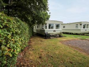 two mobile homes are parked in a yard at 6 Old Orchard in Much Wenlock