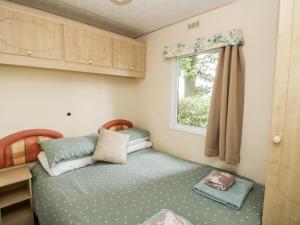 a small bedroom with a bed and a window at 6 Old Orchard in Much Wenlock
