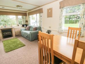 a living room with a table and a couch at 8 Old Orchard in Much Wenlock