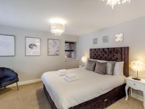 um quarto com uma cama grande e uma cadeira azul em Queen Anne Suite em Stanhope