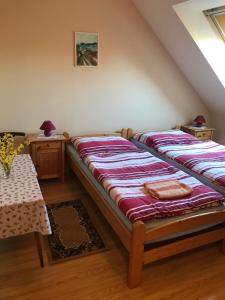 - une chambre mansardée avec 2 lits et une table dans l'établissement Falubíró Vendégháza, à Bekölce
