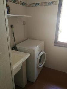 een kleine badkamer met een wasmachine en een wastafel bij Villa Centauro in Torre delle Stelle