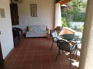 een patio met een tafel en stoelen en een bank bij Villa Centauro in Torre delle Stelle