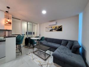 a living room with a couch and a table at Stan m&s, Boulevard-centar grada in Banja Luka +6 photos