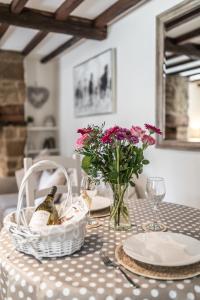 uma mesa com uma garrafa de vinho e flores em Rose End Cottage, a Luxury Getaway em Adlestrop