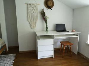 białe biurko z laptopem i stołkiem w obiekcie Sielanka Aleksandria w mieście Aleksandria