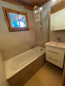 a bathroom with a shower and a tub and a sink at Chalet Singlinaz in Zinal