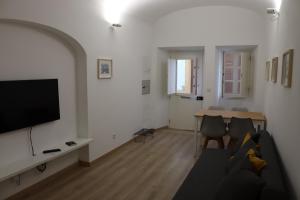 sala de estar con sofá, TV y mesa en The Sketchers House - Private Art Gallery, en Évora