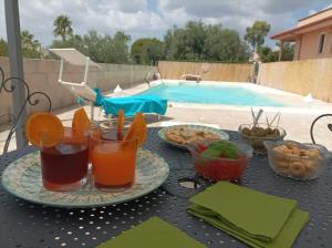 tavolo con piatti di cibo e bevande e piscina di B&B CASA NISI a Villa Castelli