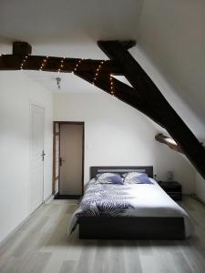 a bedroom with a large bed in a attic at Appartement au pied du circuit de Magny-cours in Magny-Cours