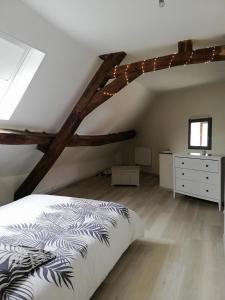 een slaapkamer met een bed en een dressoir op zolder bij Appartement au pied du circuit de Magny-cours in Magny-Cours