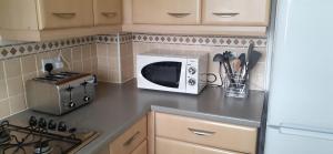 a kitchen with a microwave and a counter top at Hawksworth House, Birmingham Near NEC, HS2, Jaguar Land Rover, Bear Grylls Centre, Resorts World and Birmingham airport with a garage and free allocated parking in Kingshurst