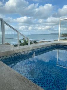 a swimming pool with a view of the ocean at Villa frente al Mar cerca a Barranquilla in Tubará
