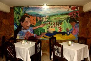 un mural en un restaurante con dos mesas en Hotel Antigua, en San Cristóbal de Las Casas