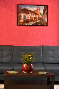 un jarrón en una mesa delante de un sofá en Hotel Antigua en San Cristóbal de Las Casas