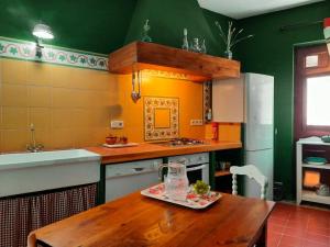 Il comprend une cuisine équipée d'une table en bois et d'un réfrigérateur. dans l'établissement Casa Inma, à Miraflores de la Sierra