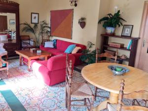 a living room with a red couch and a table at Casa Inma in Miraflores de la Sierra