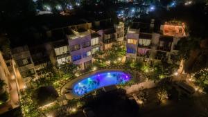 an overhead view of a building with a pool at night at Luxury Condos Macondo Tulum in Tulum