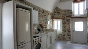 a kitchen with a sink and a refrigerator at Traditional Holiday Home in Astypalaia