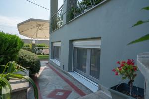- un bâtiment blanc doté d'un balcon avec un parasol dans l'établissement Apollon house, à Vólos
