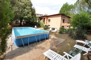 einen Pool in einem Garten mit Stühlen und einem Haus in der Unterkunft Villa Elisa in Bientina