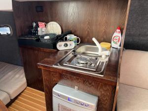 a kitchen with a stove and a sink in a caravan at VIP JACHT in Polańczyk