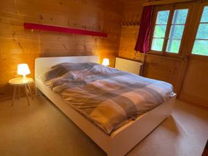 a bedroom with a bed and two lamps in it at Chalet Singlinaz in Zinal