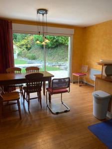 d'une salle à manger avec une table, des chaises et une fenêtre. dans l'établissement Maison située au Val de Baubère, petite vallée à coté du village de Seix, à Seix