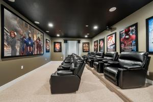 a movie room with black leather reclining chairs and posters at Encore Resort and Water Park at Reunion by Rentyl in Kissimmee