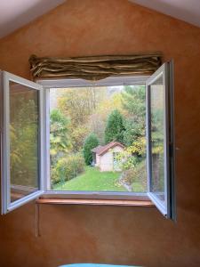 ein Fenster in einem Zimmer mit Blick auf einen Hof in der Unterkunft Maison située au Val de Baubère, petite vallée à coté du village de Seix in Seix